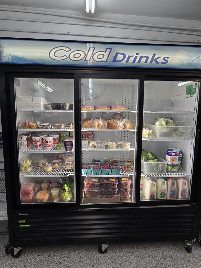 Refrigerator stocked with yogurt, milk, and fresh food